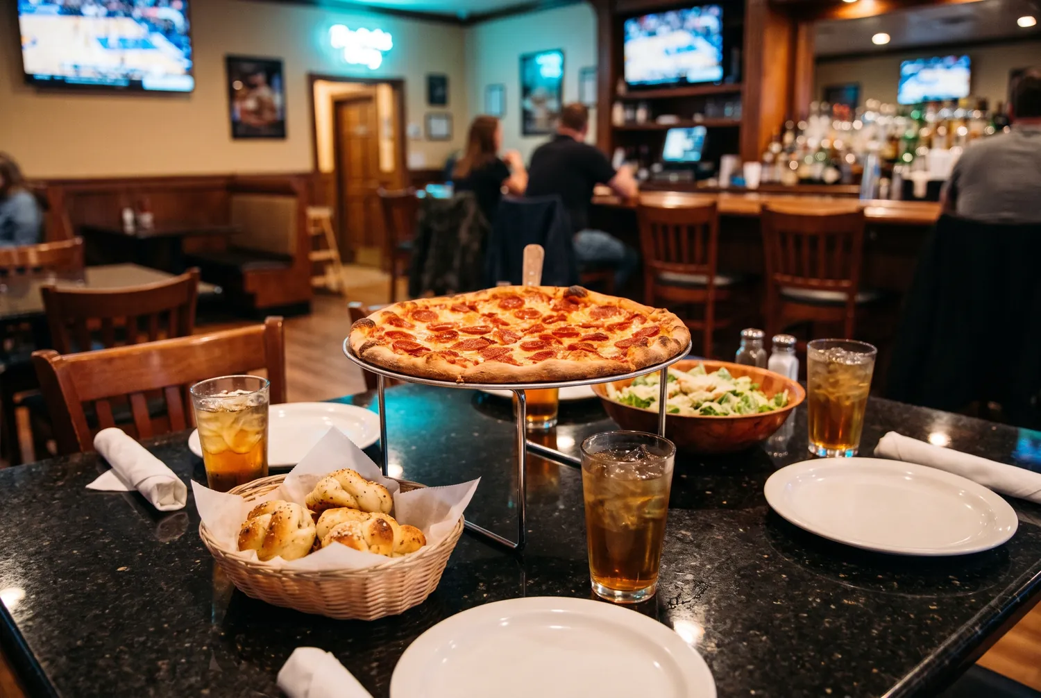 NY-style pepperoni pizza, garlic knots and salad on a table at a downtown San Diego pizzeria NY-style pepperoni pizza, garlic knots and salad on a table at a downtown San Diego pizzeria